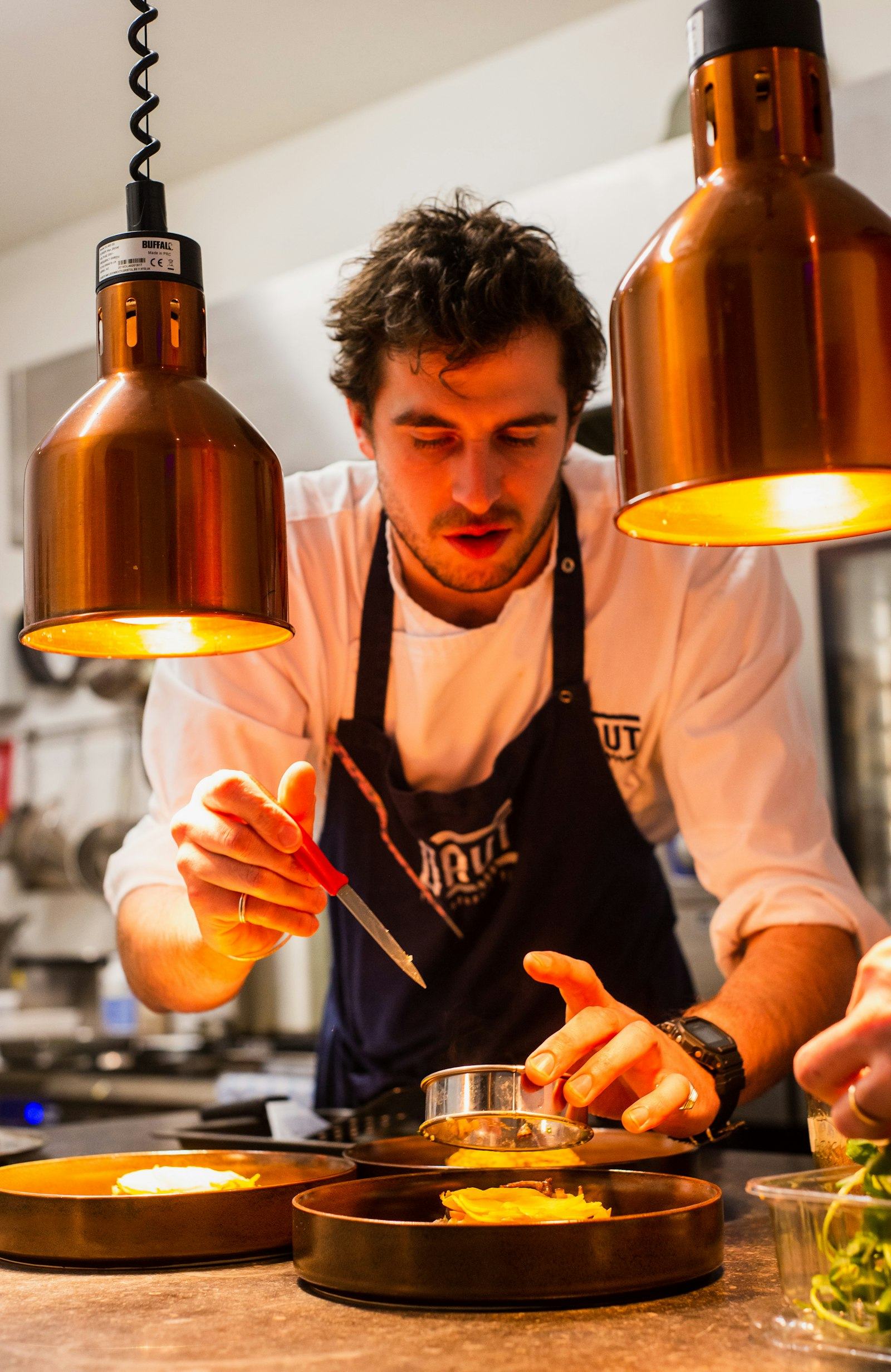 Le chef Théo Vialard en cuisine, concentré sur un dressage